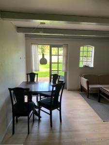 a dining room with a table and chairs and a couch at Dyrlundgård in Helsinge