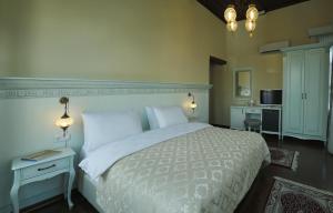 una camera con un grande letto bianco e una scrivania di Bursa İpekyolu Hotel a Bursa