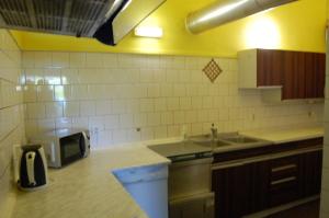 una cocina con fregadero y microondas en una encimera en Penzion Levandule, en Rumburk