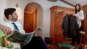 un hombre y una mujer mirando un traje en un muñeco en Hotel Kristberg en Lech am Arlberg