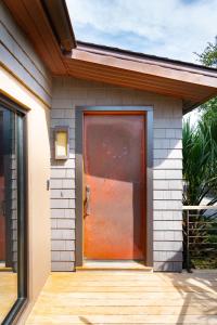 a red door on a house with a wooden porch at Folly Vacation 620 Entire Home plus Apt, one block to the beach and pet friendly in Folly Beach