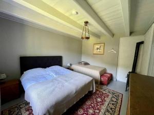 a bedroom with two beds and a rug in it at Bosvik Gård, nyrenovert leilighet i hovedhus fra 1756 in Risør