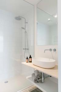 Baño blanco con lavabo y espejo en High-end flats at South area, en Amberes