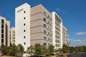 a tall white building with a green sign on it at Element Arundel Mills BWI Airport in Hanover