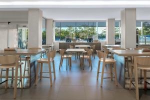 a dining room with tables and chairs and windows at Element Arundel Mills BWI Airport in Hanover