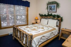 a bedroom with a large bed with a wooden frame at Timber Creek Chalets- 8 chalet in Estes Park