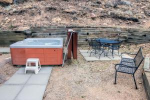 a patio with a hot tub and a table and chairs at Timber Creek Chalets- 8 chalet in Estes Park +3 photos