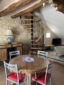 a dining room with a wooden table and chairs at Gite des vieilles pierres in Seigy