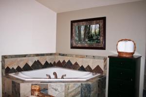 a bath tub in a bathroom with a mirror at Fawn Valley Inn- 106 condo in Estes Park