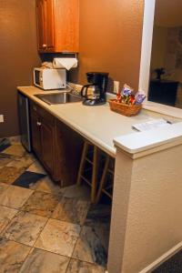a kitchen counter with a sink and a microwave at Fawn Valley Inn- 106 condo in Estes Park
