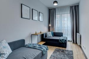 ein Wohnzimmer mit einem Sofa und einem Stuhl in der Unterkunft LM APARTAMENTY NARUTOWICZA Kamienica Nova 2-3 in Stettin