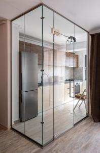 een glazen keuken met een koelkast in een kamer bij Kondo studio I Roka Residence, Timpuri Noi in Boekarest