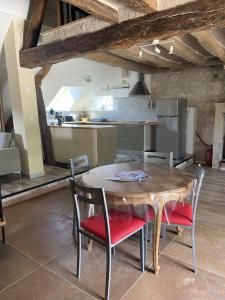 a kitchen with a wooden table and chairs in a room at Gite des vieilles pierres in Seigy
