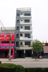 un grand bâtiment blanc dans une rue de la ville dans l'établissement Sonne Hotel Quang Binh, à Ðộng Hỏi