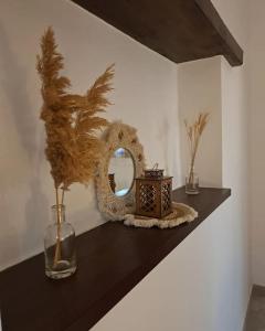 une étagère avec un miroir et un vase sur elle dans l'établissement Ηλιοβασίλεμα, à Chios