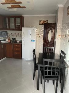 Appartement tarik : مطبخ مع طاولة سوداء وثلاجة بيضاء