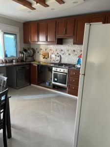 - une cuisine avec des placards en bois et un réfrigérateur dans l'établissement Appartement tarik, 