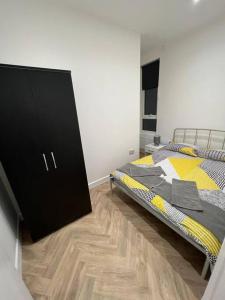 1 Schlafzimmer mit 2 Betten und einem schwarzen Schrank in der Unterkunft Ground Flr 3-bed flat near Norbury Station in Norbury