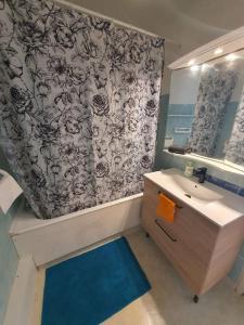 ein Bad mit einem Waschbecken und einem Duschvorhang in der Unterkunft Proche Paris-Château Versailles-St Germain in Marly-le-Roi