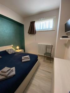 Un dormitorio con una cama azul con toallas. en B&B Tirassegno, en Agnone