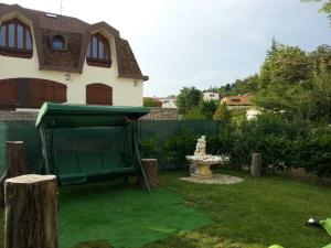 a backyard with a green lawn with a house at B&B Tirassegno in Agnone +6 photos