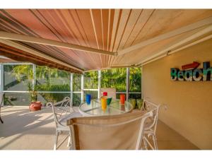 a table and chairs in a room with a porch at Villa Hideaway, Cape Coral in Cape Coral