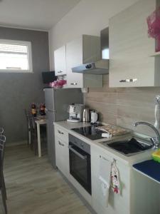 a kitchen with white cabinets and a stove top oven at B&B Tirassegno in Agnone