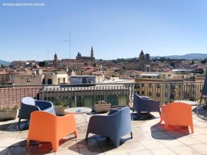 a patio with chairs and tables and a view of a city at B&B 52cento in Arezzo