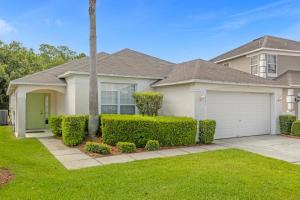 a house with a green door and bushes at 1061 Lake Berkley 4 Bed with Pool&Spa in Kissimmee