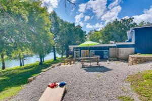 a picnic table with an umbrella in front of a building at Kimberling City Escape with Dock Access and Boat Slips in Kimberling City