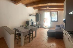a kitchen and living room with a table and a couch at Sa domo e Peppa in Nuoro
