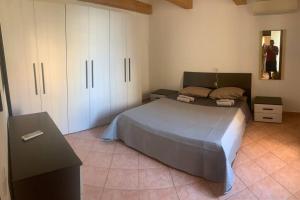 1 dormitorio con 1 cama grande y armarios blancos en Sa domo e Peppa, en Nuoro