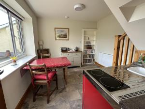 A lovely 1 bedroom annexe with kitchenette في Kidwelly: مطبخ بطاولة وقمة كونتر