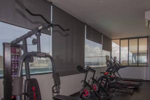 un gimnasio con 3 bicicletas en una habitación con ventanas en Brand new, with private Jacuzzi en Carlos Guerra