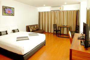 a bedroom with a bed and a desk and a television at Double DD House at MRT Sutthisarn in Bangkok