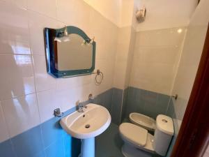 a bathroom with a sink and a toilet and a mirror at Roel apartments Shkodra Center in Shkodër