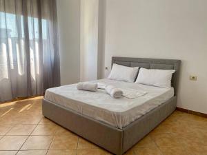 a bed with two towels on it in a bedroom at Roel apartments Shkodra Center in Shkodër +7 photos