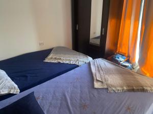Duas camas num quarto com cortinas cor de laranja em قريه نيوكوست em Dawwār Muḩammad Abū Shunaynah