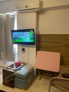 uma sala de estar com uma televisão e uma cadeira em قريه نيوكوست em Dawwār Muḩammad Abū Shunaynah