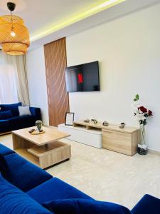 Rafina A12 في الدار البيضاء: غرفة معيشة مع أريكة زرقاء وتلفزيون