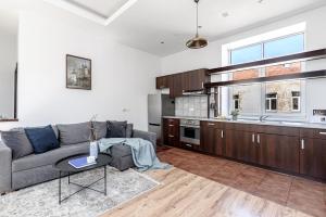 a living room with a couch and a kitchen at Spacious City Centre Apartment with Parking SELF CHECK-IN in Vilnius
