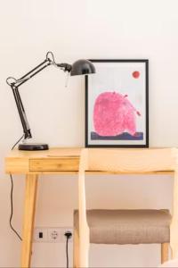 un escritorio con una lámpara y una foto en él en Charming apartment by the river, en Alcácer do Sal