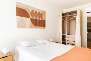 um quarto com uma cama branca e um closet em Charming apartment by the river em Alcácer do Sal