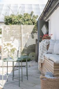 a patio with a couch and a table at Villa Verde Österlen in Glemminge