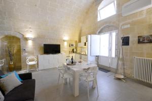 cocina y sala de estar con mesa y sillas en Vivere nei Sassi, en Matera