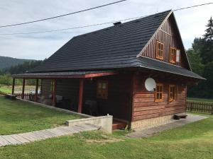 a log cabin with a black roof at Apartmány Podťaté in Velké Karlovice