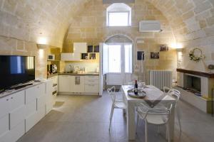 a kitchen with a table and chairs and a tv at Vivere nei Sassi in Matera
