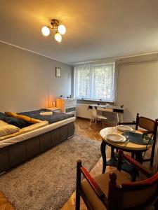 a bedroom with a bed and a table and a desk at Gdańsk Sea Apartment by YOCA in Gdańsk