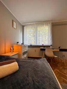 a bedroom with a bed and a desk and a window at Gdańsk Sea Apartment by YOCA in Gdańsk