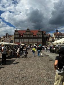 a group of people walking down a street in front of a building at Gdańsk Sea Apartment by YOCA in Gdańsk